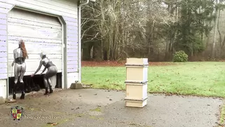 Two Babes In Tight Latex Suits Move The Box To Its Place