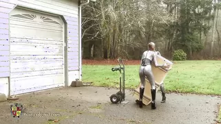 Two Babes In Tight Latex Suits Move The Box To Its Place